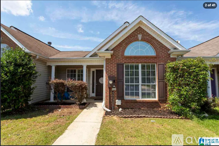 A house with a brick facade and a large arched window.