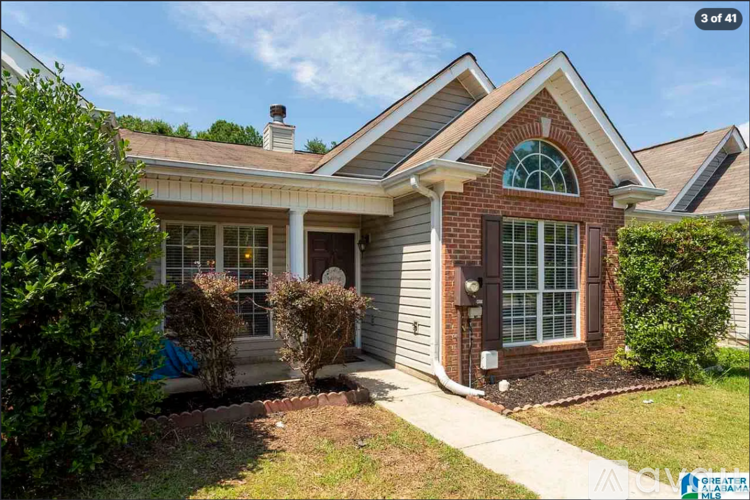 A house with a brick facade and a large window.