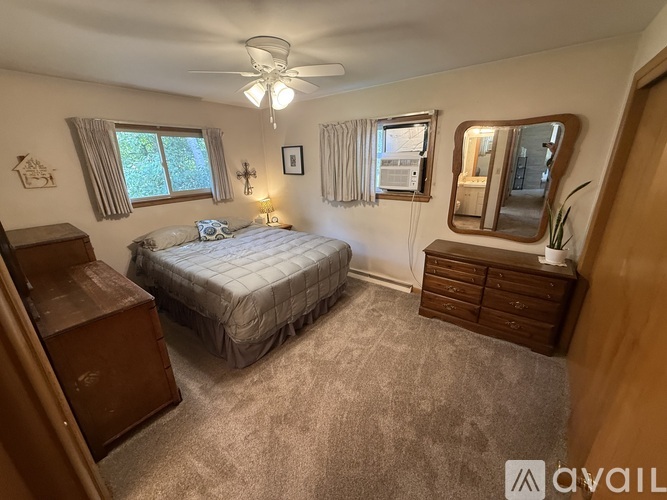 A bedroom with a bed, dresser, and mirror.