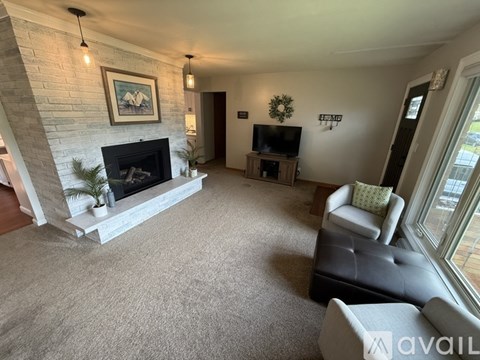 A living room with a fireplace and a flat screen TV.