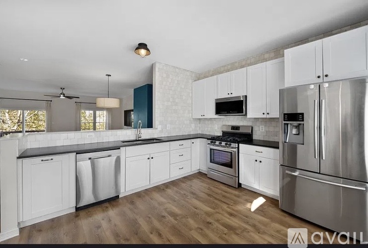 A kitchen with white cabinets and stainless steel appliances.