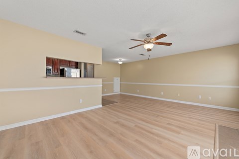 A spacious room with a ceiling fan and lighting fixture.