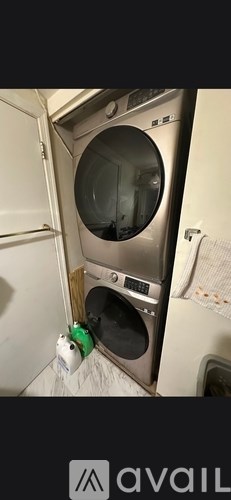A washing machine with a green bottle next to it.