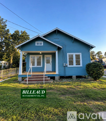 A blue house with the name Billeaud Management Co. Inc. on the lawn.
