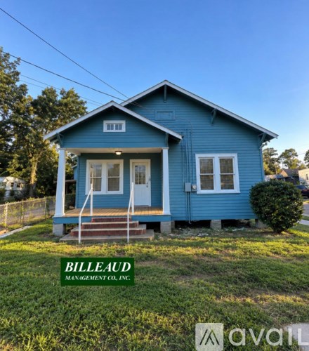A blue house with the name Billeaud Management Co. Inc. on the lawn.