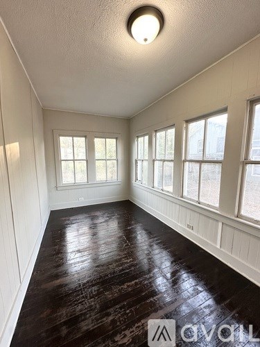 A room with white walls and a dark wooden floor.