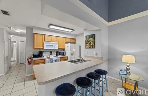 A kitchen with a counter and bar stools.