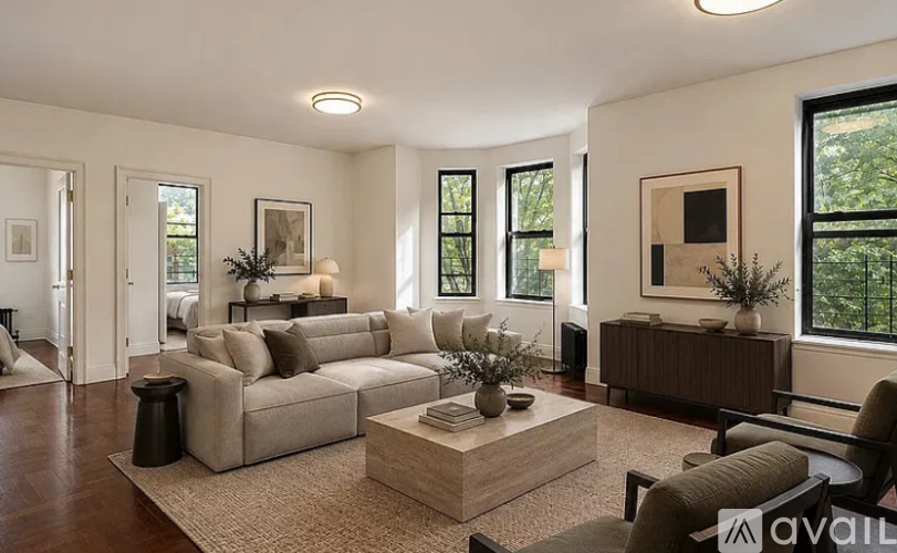 A living room with a beige sofa, a coffee table, and a large window.