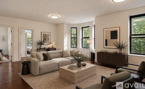 A living room with a beige sofa, a coffee table, and a large window.