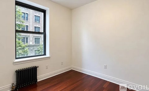 A room with a window and a radiator on the wall.