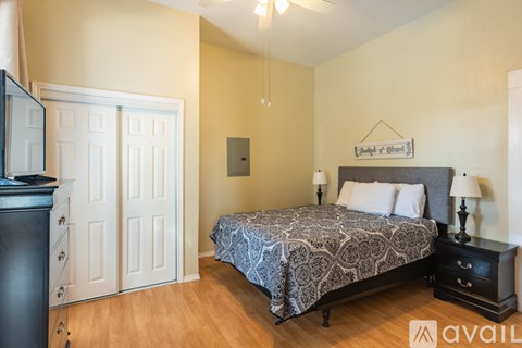 A bedroom with a bed, nightstand, and a television.