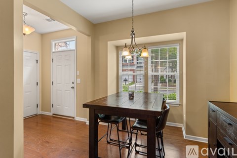 A dining room with a wooden table and chairs.