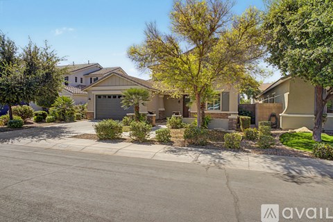 A house with a driveway and trees in front of it.