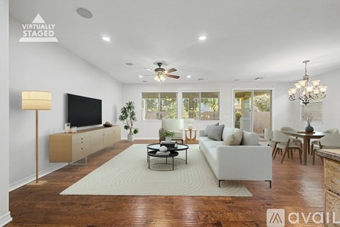A living room with a television, a couch, and a rug.
