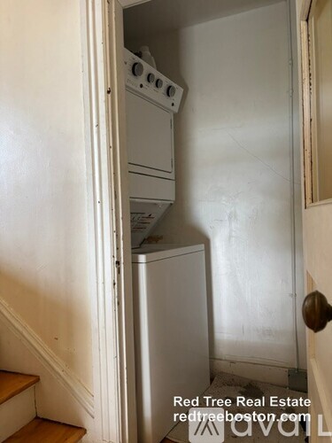 A white oven and dishwasher are in a narrow hallway.