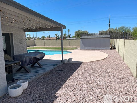 A patio with a pool table and a pool in the backyard.