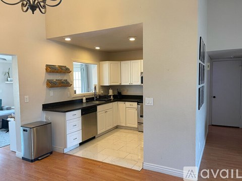 A kitchen with white cabinets and a black countertop.