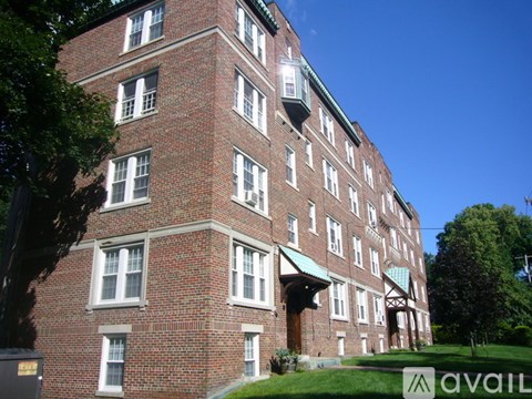 A red brick building with a green roof and white trim.