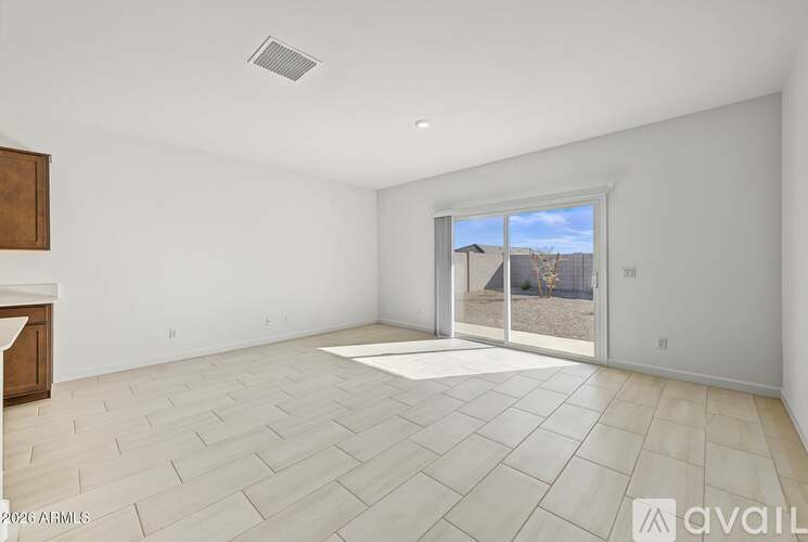 A spacious empty room with a large window and sliding glass door.