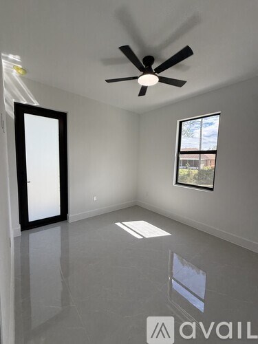 A room with a ceiling fan and a window.