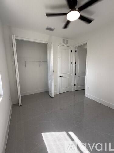 A room with a ceiling fan and a door.