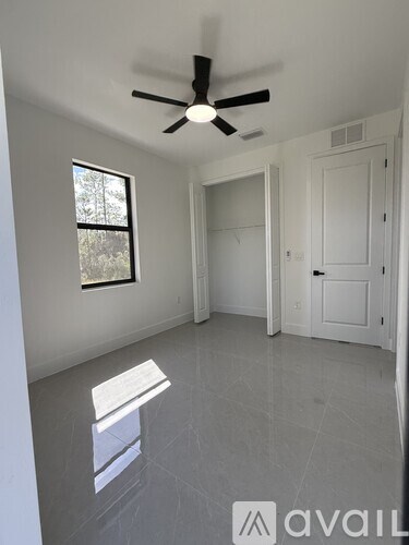 A room with a ceiling fan and a window.