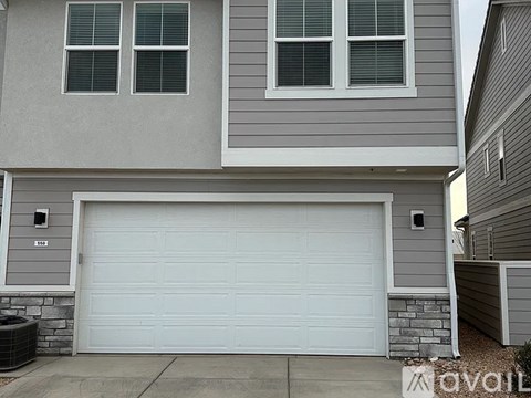 A two-story house with a white garage door.