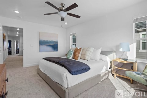 A bedroom with a large bed and a ceiling fan.