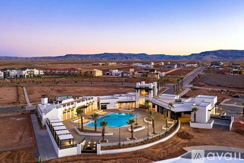 A resort with a pool and palm trees in the desert.