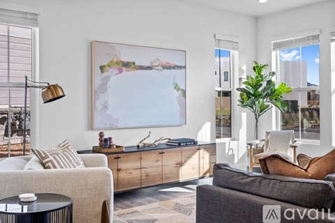 A living room with a large painting on the wall and a couch.