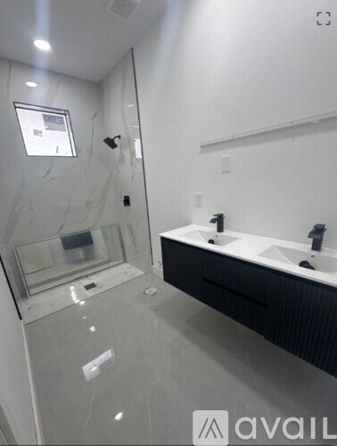 A bathroom with a glass shower stall and a sink.