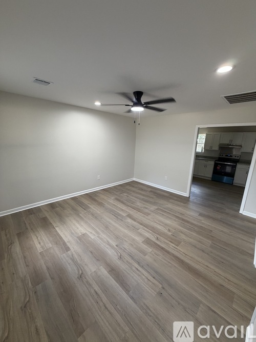 A room with wooden flooring and a ceiling fan.