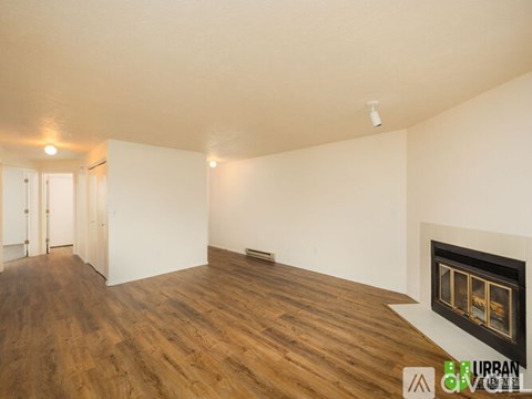 A room with a fireplace and wooden floors.