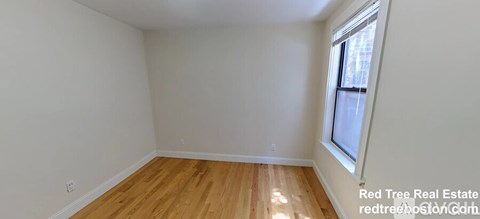 A room with wooden flooring and a window.