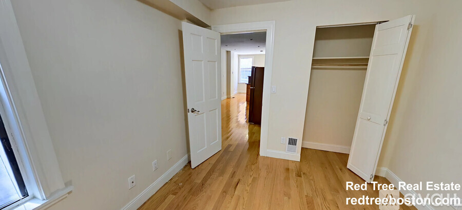 A room with a white door and a white wardrobe.