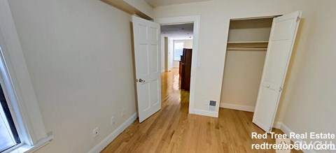 A room with a white door and a white wardrobe.
