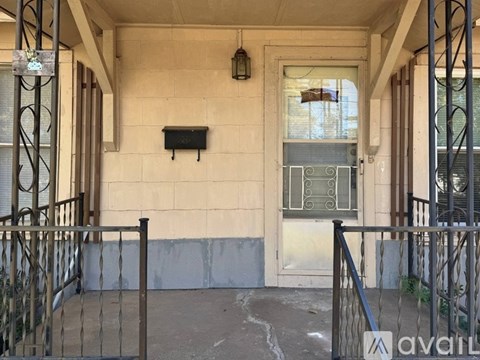 A balcony with a metal railing and a window with bars.