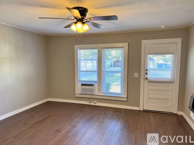 A room with a ceiling fan and a window with blinds.