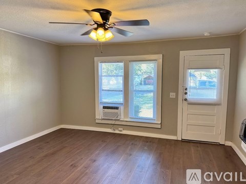 A room with a ceiling fan and a window with blinds.