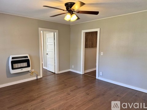 A room with a ceiling fan and a wall-mounted air conditioner unit.