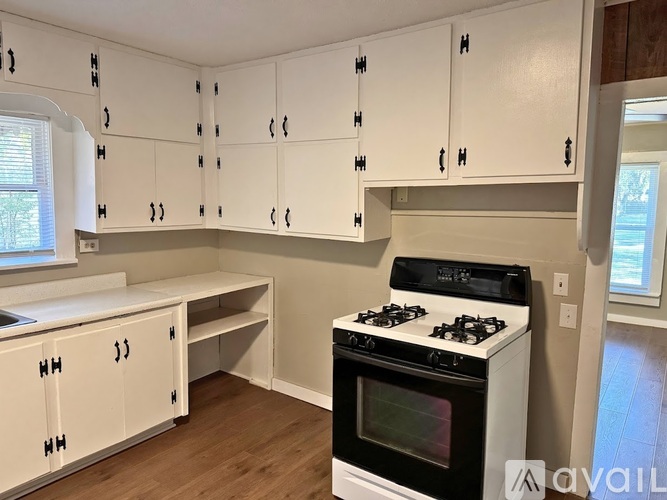 A kitchen with white cabinets and a black stove top oven.