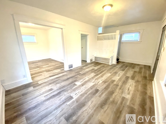 A room with wooden flooring and white walls.