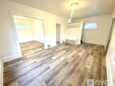 A room with wooden flooring and white walls.