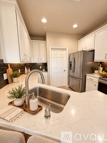 A kitchen with a marble countertop and stainless steel appliances.