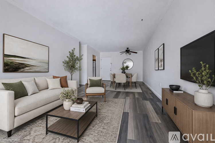 A living room with a white couch, a coffee table, and a painting on the wall.