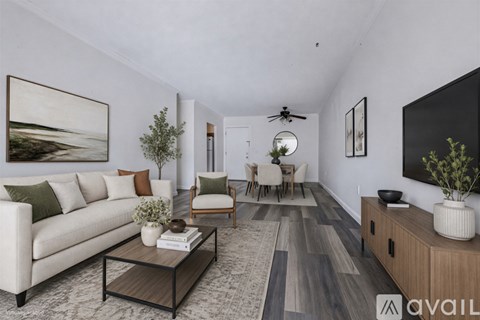 A living room with a white couch, a coffee table, and a painting on the wall.