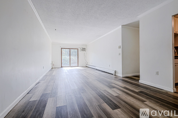 A room with wooden flooring and a window.