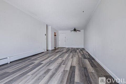 A room with wooden flooring and a ceiling fan.