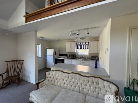 A kitchen with a white sofa in front of it.