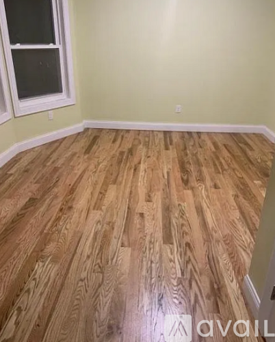 A room with wooden flooring and a window.